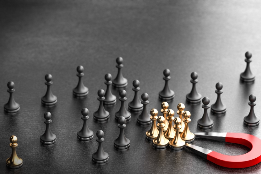 black and gold chess pieces with a magnet drawing gold ones into a group